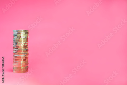 Stacked Pound Coins on Pink Background with Negative Copy Space