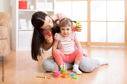 kid and mother play together with puzzle toy