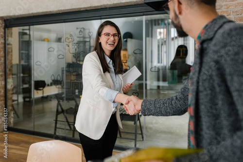 Smiling plainly and firmly handshaking with human resource manager