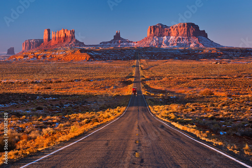 A road leading to Monument Valley with red truck going at camera, Usa