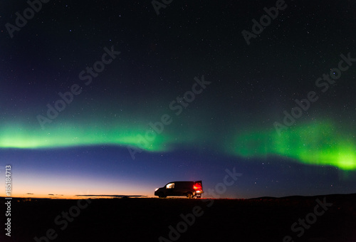 The northern lights above a camper van after sunset in Iceland. 