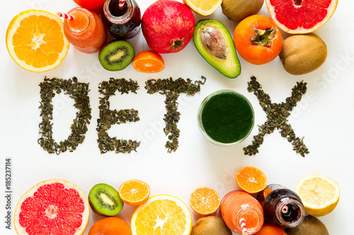 Healthy eating concept. Word 'detox' from green tea with colorful smoothies and fruits. Top view