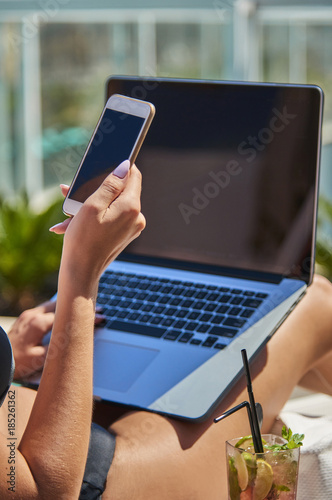 Kobieta pracująca na laptopie. Dziewczyna na wakacjach. Praca w podróży. Praca zdalna. Na basenie.