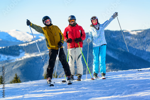 Three happy skiers having fun on winter ski slope
