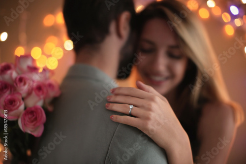 Happy couple dancing together against blurred lights on engagement day