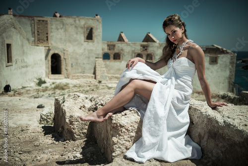 Portrait of beautiful young girl in a ruined fishers village in Sicily, Siracusa. 