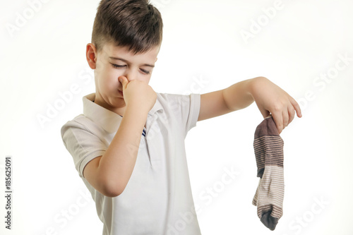 Studio shot of young boy holding stinky sock