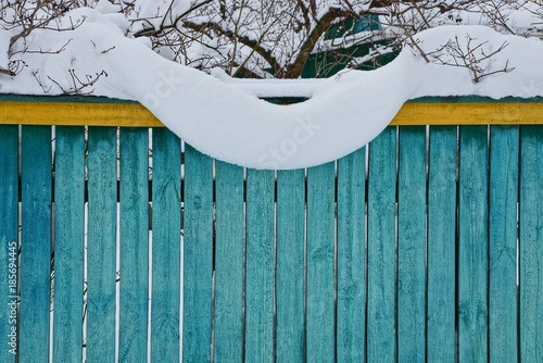 жёлто зелёный деревянный забор под белым снегом
