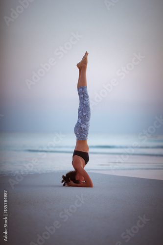 Summer yoga session on a beautiful golden beach of Maldives yoga tour, Salamba Sirsasana - supported headstand