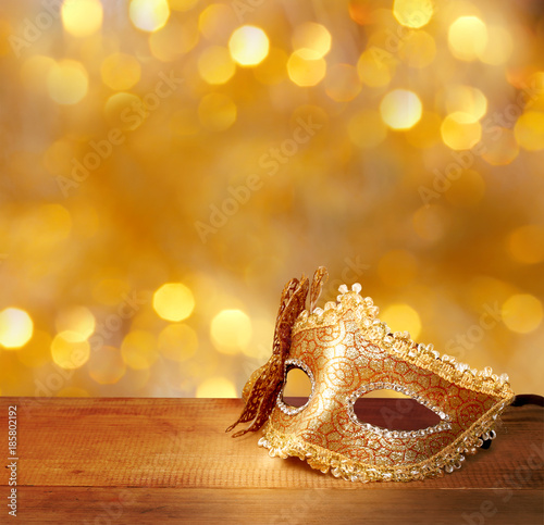 Traditional female carnival venetian mask on table .Masquerade mask on glitter background.Mardi Gras.