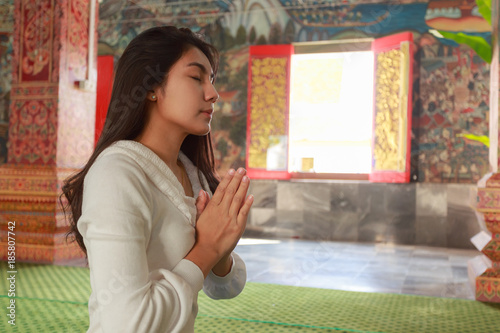 Asian woman pay homage to a Buddha image