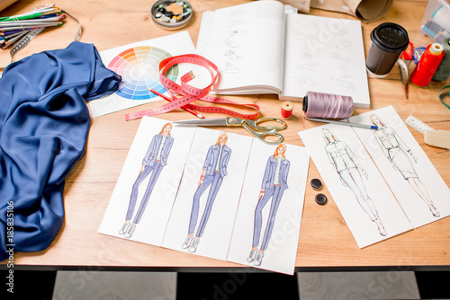 View on the tabel with fashion drawings and tailoring tools
