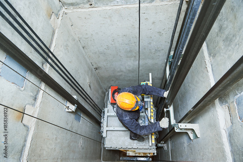 lift machinist repairing elevator in lift shaft