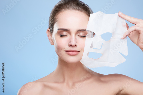 Woman removing mask from face