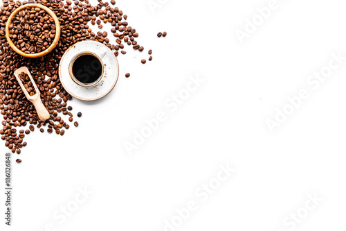 Coffee concept. Roasted beans and cup of espresso on white background top view copyspace