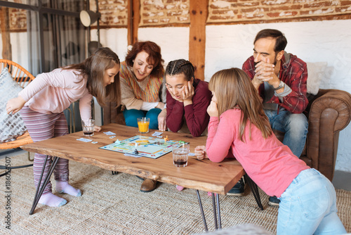 Happy family at home in the couch playing classic table games .