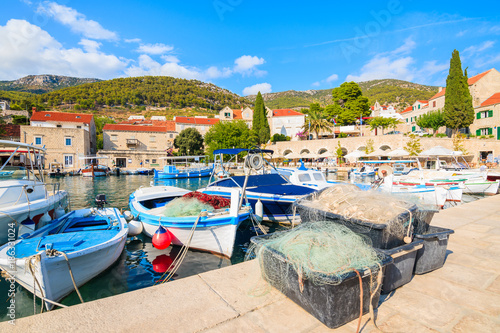 Baskets with fishing nets and colorful boats in Bol port, Brac island, Croatia