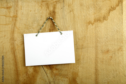 Pusta biała karta na drewnianej desce, drzwiach.