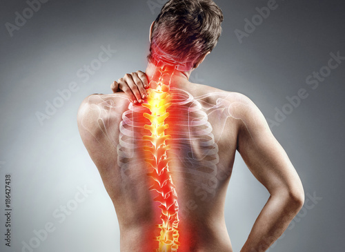 Young man holding his neck in pain. Medical concept.