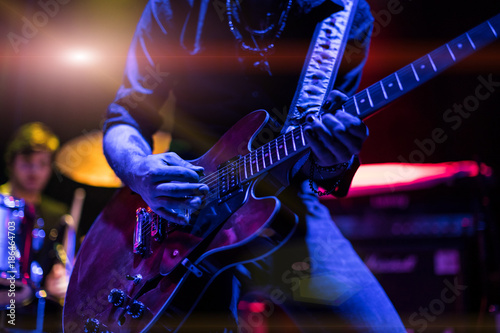 A rocker is playing guitar on stage.