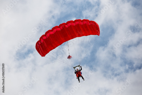 Parachuter descending with a red parachute