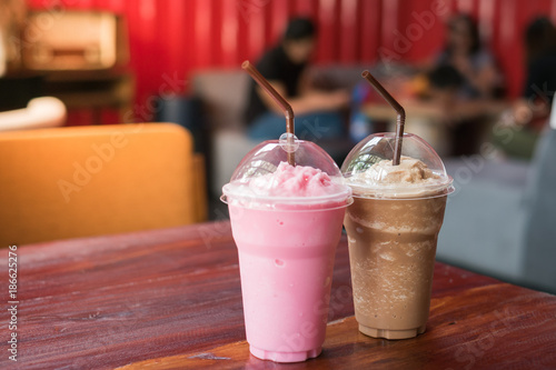 Pink milk and cocoa on table in cafe 