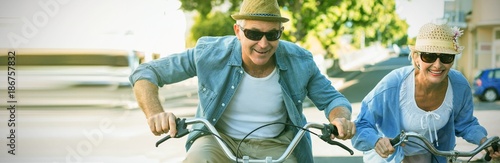 Happy mature couple going for a bike ride in the city