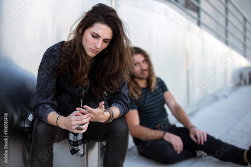 Worried sad unemployed people sitting on sidewalk feeling despair and hopeless