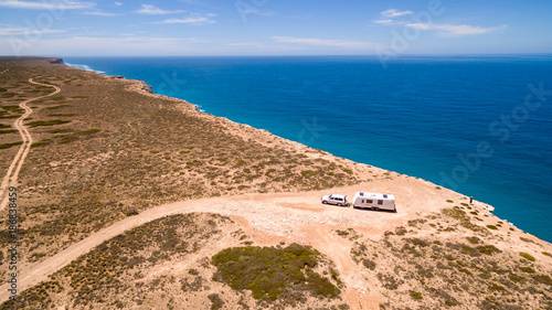 Aerial view of four wheel drive vehicle and caravan parked at The Great Australian Bight on the Edge of the Nullarbor Plain