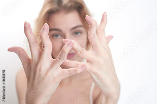 Hypermobility of the joints. The girl flexes the fingers on white background
