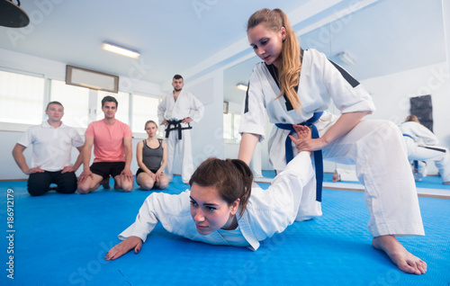 Young females are training in pair to use taekwondo technique