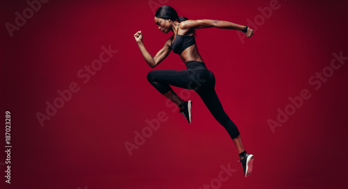 Sports woman running over red background