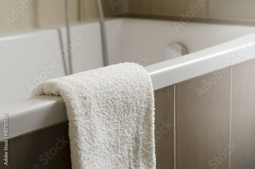 White towel on the bath in bathroom with brown ceramic shallow