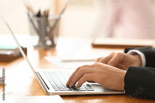 Man working on laptop in office, closeup