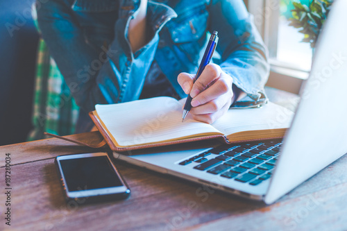 Woman hands with pen writing on notebook in the office.