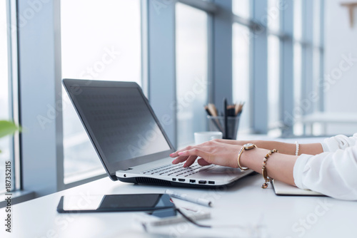 Female copywriter at her workplace, home, writing new text using laptop and Wi-Fi internet connection in the morning.