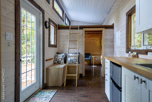 Interior design of a dining room and kitchen in a tiny rustic log cabin.