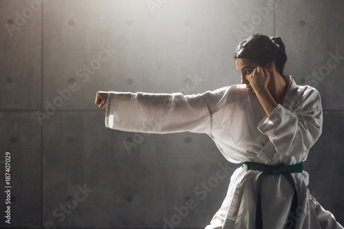 Martial arts Concept. Young woman in kimono practicing karate