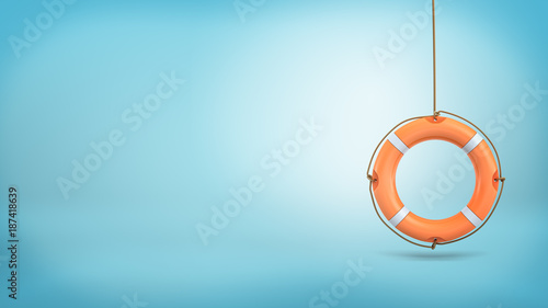 3d rendering of a single orange life buoy hangs down from a rope on a blue background.