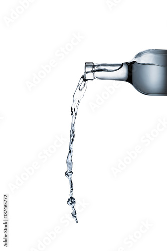 water pouring from glass bottle isolated on white