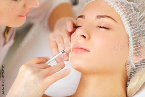 Woman receiving cosmetic injection on her face