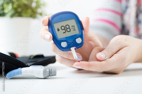 Woman checking blood sugar level by glucometer