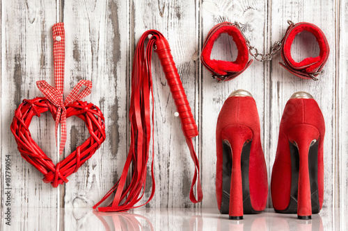 red shoes lash heart handcuffs on a wooden background