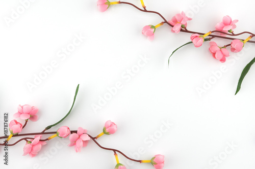 Fake pink flower branches on white background with copy space