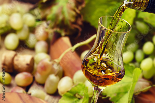 Golden Grappa Being Poured Into Shot Glass, Rustic Still Life, Selective Focus