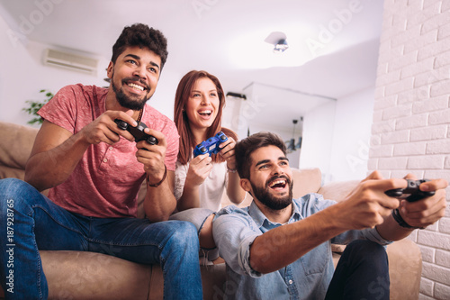 Group of friends play video games together.