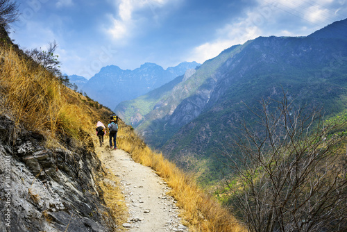 Hiking path (the high road) of Tiger Leaping Gorge. Travelers hiking in the mountains. Located 60 kilometres north of Lijiang City, Yunnan Province, China.