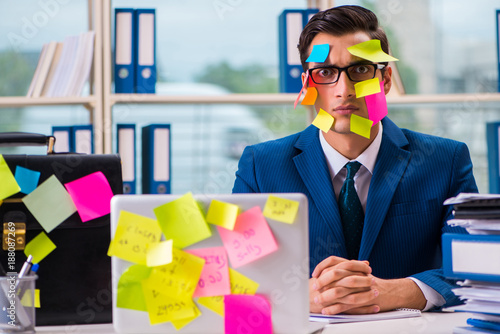 Businessman with reminder notes in multitasking concept