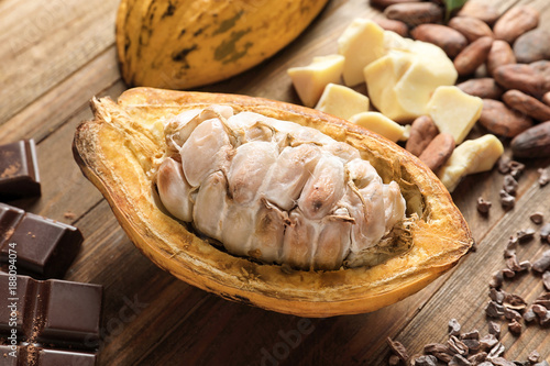 Cut cocoa pod on wooden table, closeup