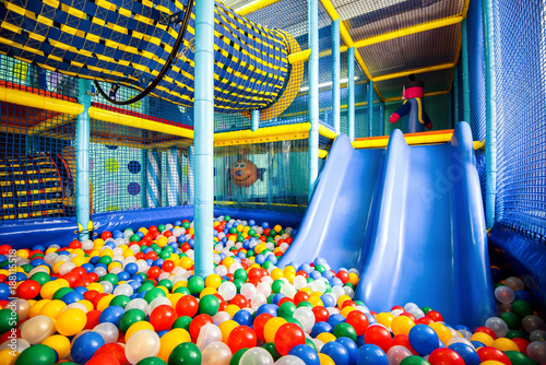 Modern children playground indoor, inside playroom with slide and dry pool